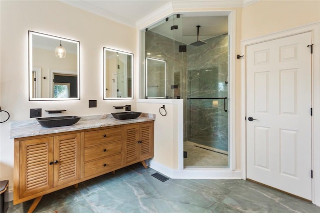 bathroom with a shower stall, crown molding, double vanity, marble finish floor, and a sink