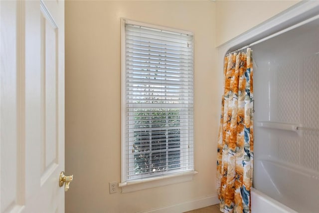 bathroom with a wealth of natural light and shower / bath combo