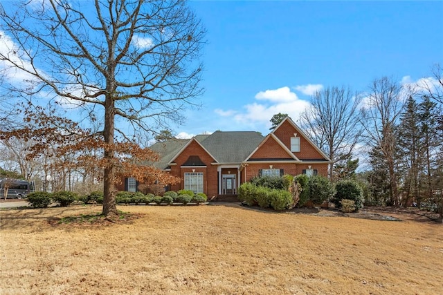 view of front of home featuring brick siding and a front lawn