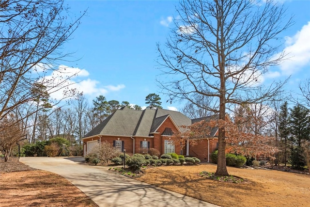 view of front facade featuring driveway, brick siding, and an attached garage