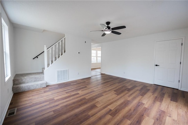 unfurnished living room featuring visible vents, stairs, ceiling fan, and wood finished floors