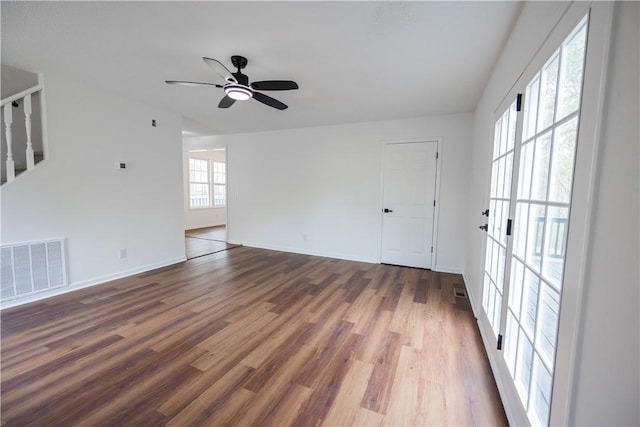 spare room featuring a ceiling fan, wood finished floors, visible vents, and baseboards