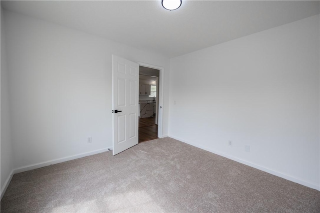 unfurnished room with baseboards and carpet floors