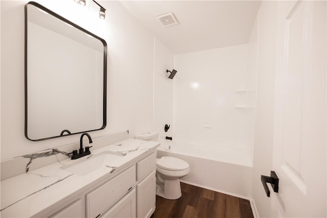 bathroom with vanity, wood finished floors, visible vents, shower / bath combination, and toilet