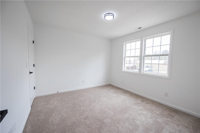 carpeted spare room with baseboards and visible vents