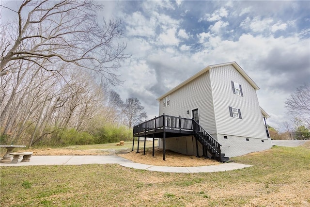 view of property exterior with a deck, stairway, and a yard