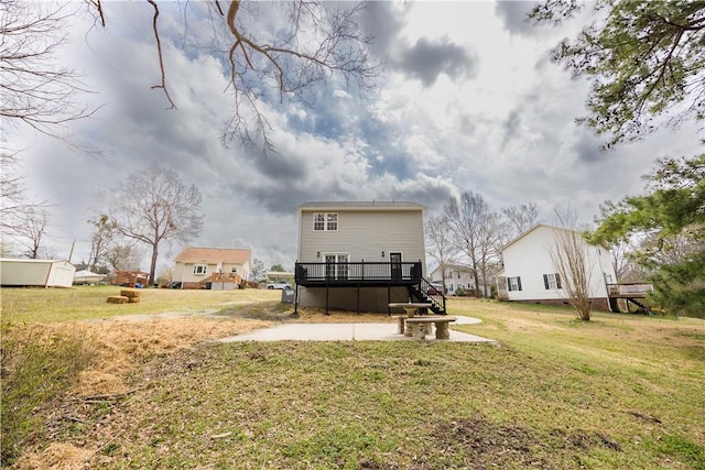 rear view of house featuring a lawn and a wooden deck