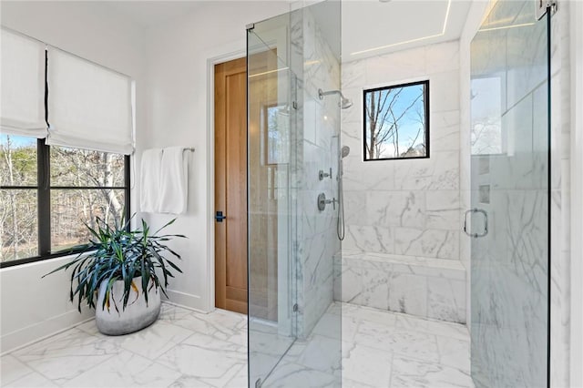 full bath featuring plenty of natural light, marble finish floor, and a marble finish shower