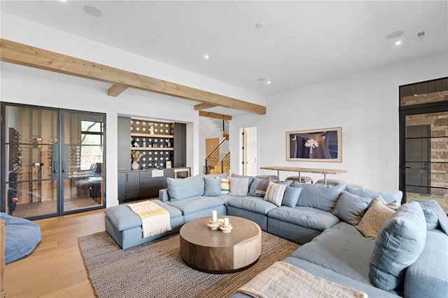 living room with stairway, a dry bar, beam ceiling, recessed lighting, and wood finished floors