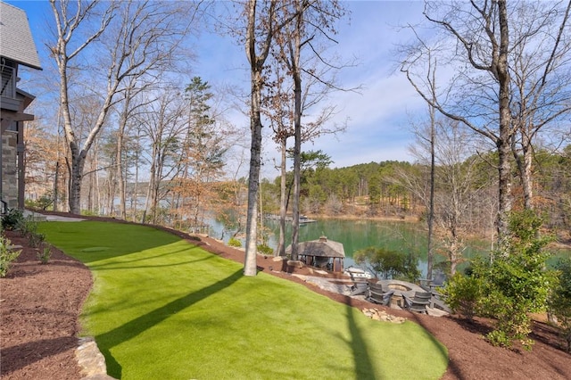 view of yard with a water view and an outdoor fire pit