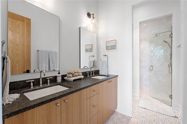 full bathroom with double vanity, a stall shower, and a sink