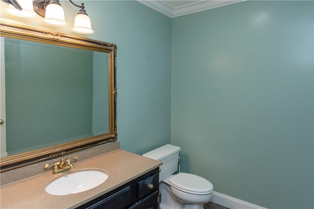 bathroom featuring vanity, toilet, baseboards, and ornamental molding