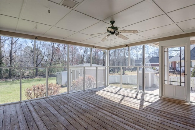 unfurnished sunroom with a drop ceiling and a ceiling fan