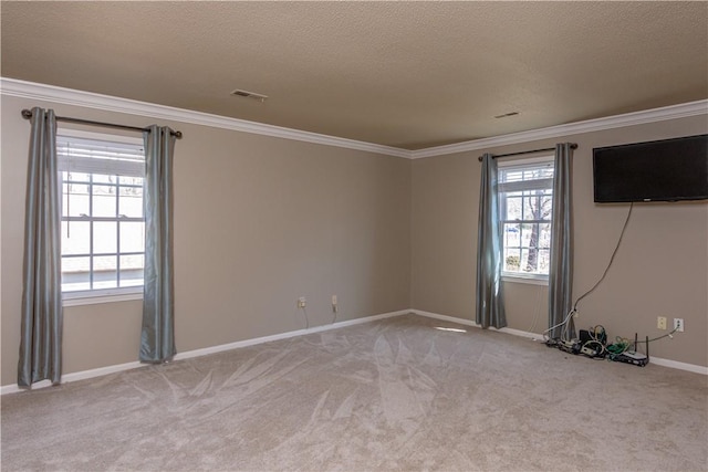 carpeted empty room featuring visible vents, baseboards, a textured ceiling, and ornamental molding