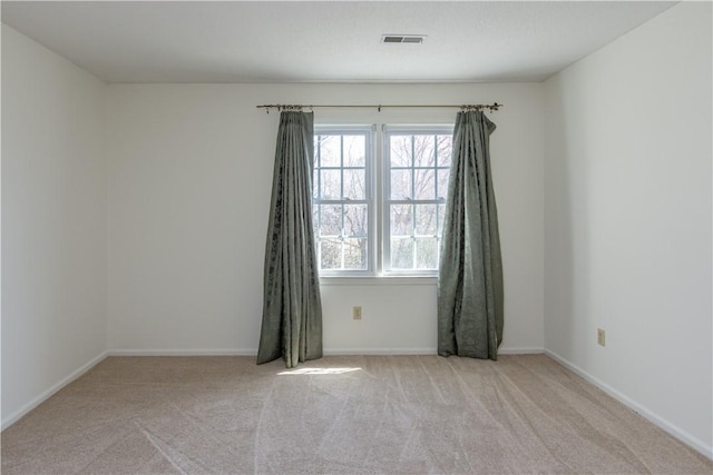 carpeted empty room with visible vents and baseboards