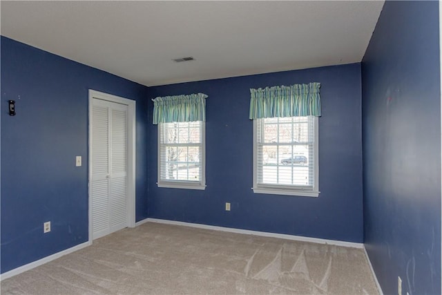 carpeted empty room with visible vents and baseboards