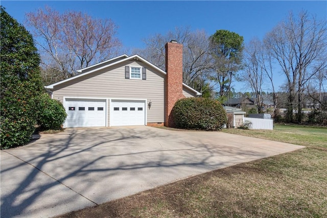 view of side of home with a lawn, driveway, and a chimney