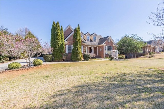 view of front of home featuring brick siding and a front lawn