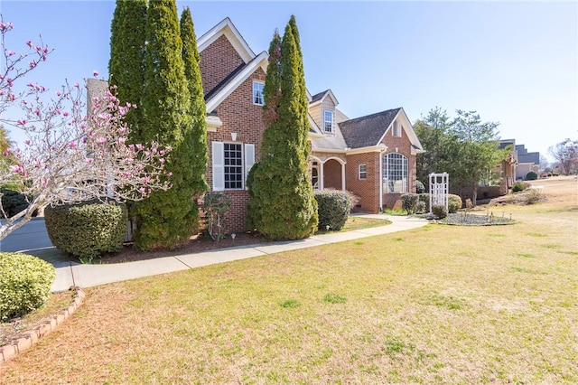 view of front facade featuring brick siding and a front lawn