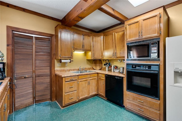 kitchen featuring beamed ceiling, light countertops, brown cabinets, black appliances, and a sink