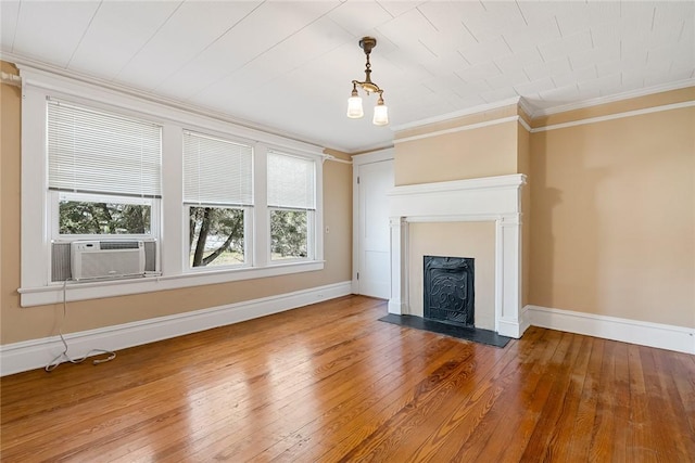 unfurnished living room featuring cooling unit, baseboards, a fireplace, hardwood / wood-style flooring, and crown molding