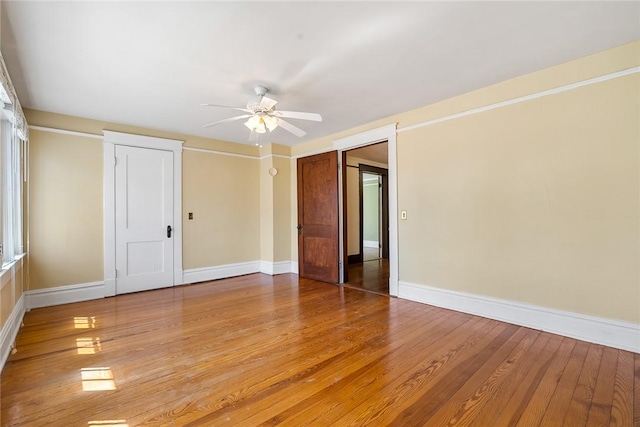 unfurnished room with a ceiling fan, baseboards, and light wood finished floors