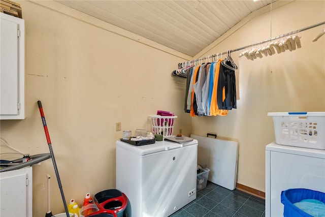 washroom featuring washing machine and clothes dryer, cabinet space, wooden ceiling, and dark tile patterned floors