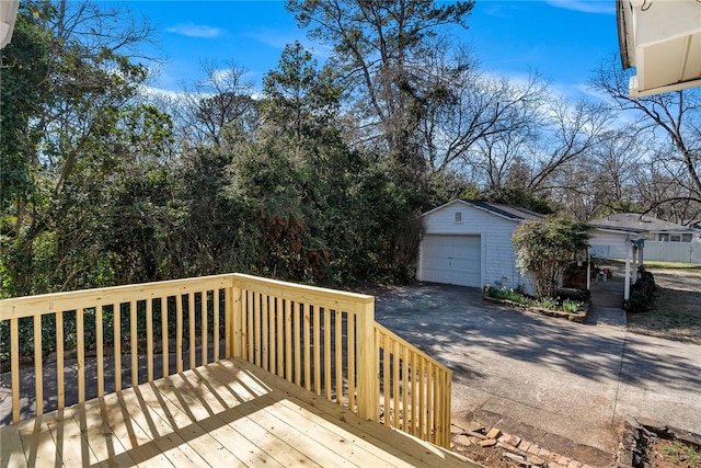 deck featuring driveway, a detached garage, and an outdoor structure