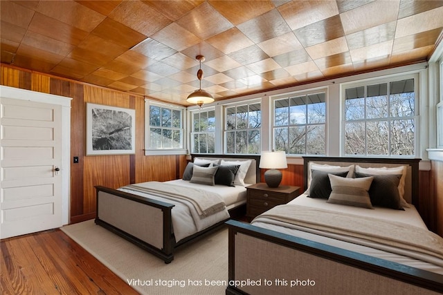 bedroom featuring wooden walls and wood finished floors