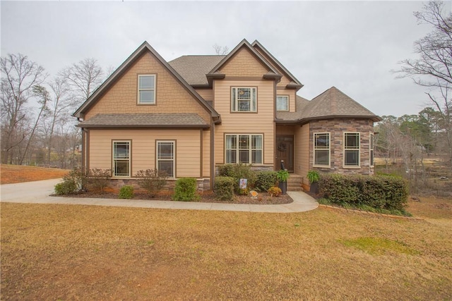 craftsman house with a front yard and stone siding