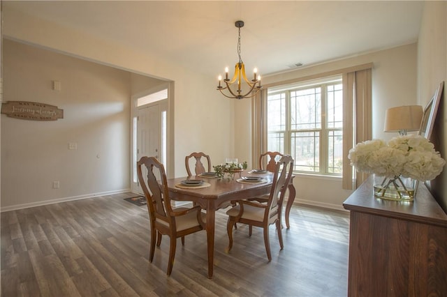 dining space with dark wood finished floors, a notable chandelier, visible vents, and baseboards