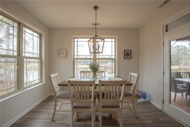 dining area featuring visible vents, plenty of natural light, and dark wood-style floors