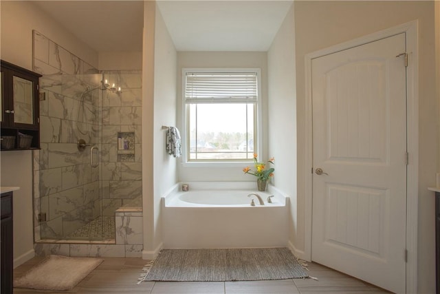 full bath with baseboards, vanity, a bath, and a shower stall