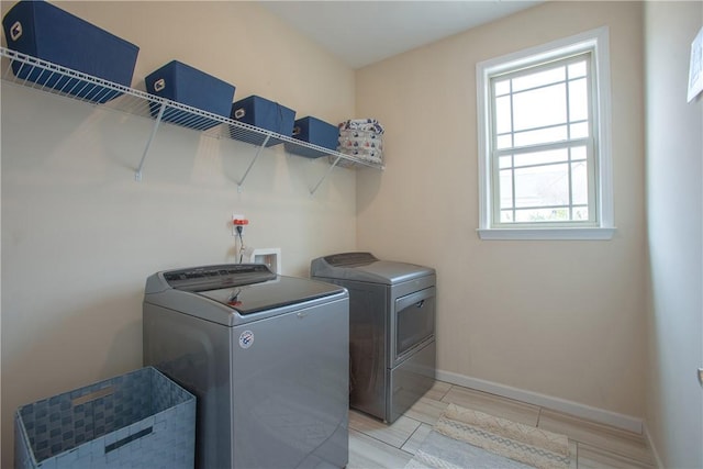 laundry room featuring baseboards, separate washer and dryer, and laundry area