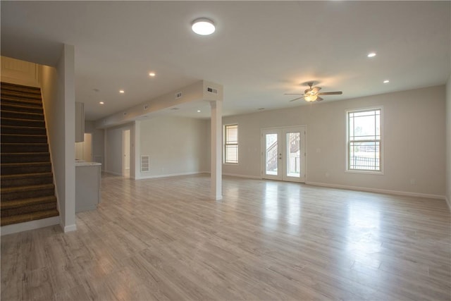 unfurnished living room featuring baseboards, light wood-type flooring, a wealth of natural light, and ceiling fan