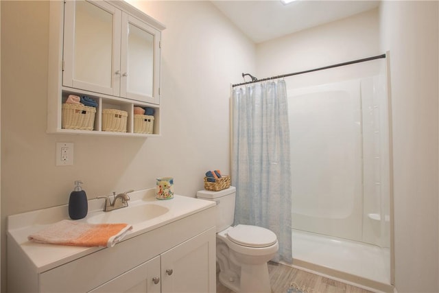 full bathroom with vanity, toilet, wood finished floors, and a stall shower