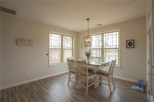 dining room with a notable chandelier, baseboards, visible vents, and dark wood-style flooring