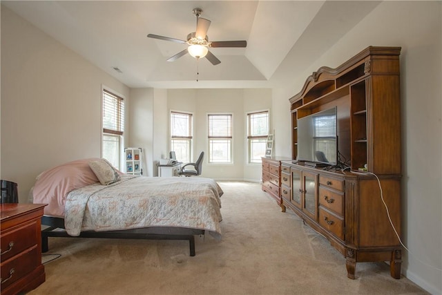 bedroom featuring a raised ceiling, a ceiling fan, baseboards, and light carpet