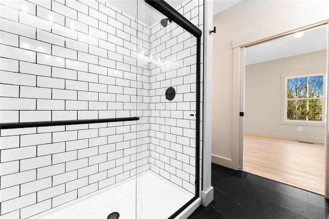 full bath featuring a shower stall, wood finished floors, baseboards, and visible vents