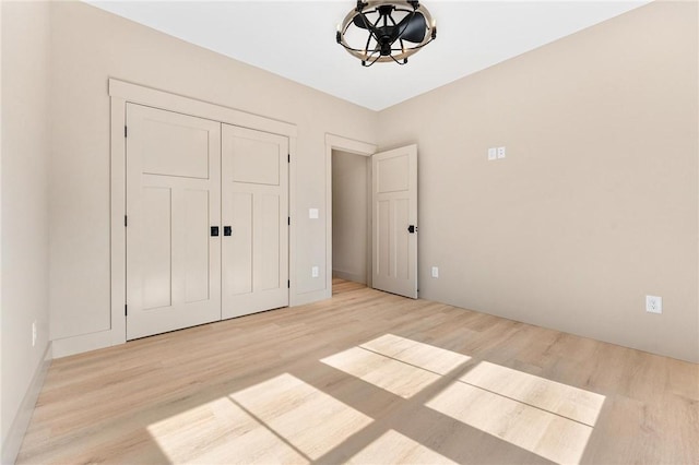 unfurnished bedroom featuring a closet and light wood-style floors