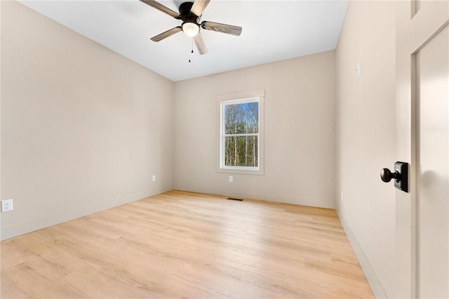empty room featuring visible vents, baseboards, light wood-style floors, and a ceiling fan