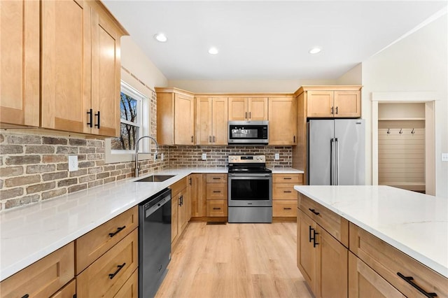 kitchen with a sink, light brown cabinets, tasteful backsplash, and stainless steel appliances