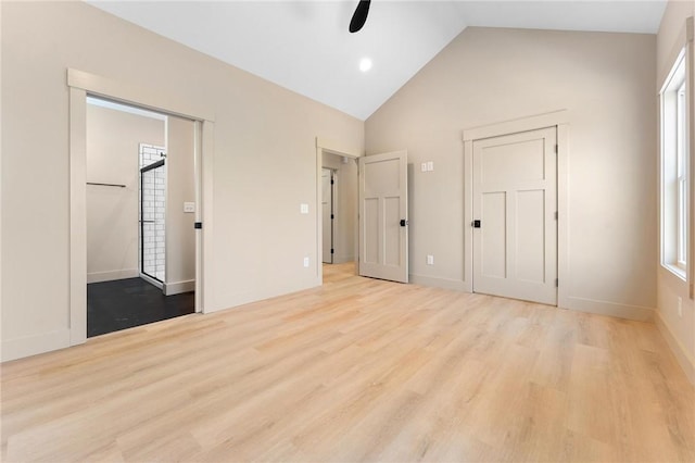 unfurnished bedroom with baseboards, high vaulted ceiling, and wood finished floors