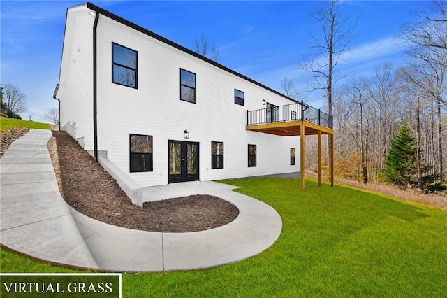 rear view of property with a lawn and french doors