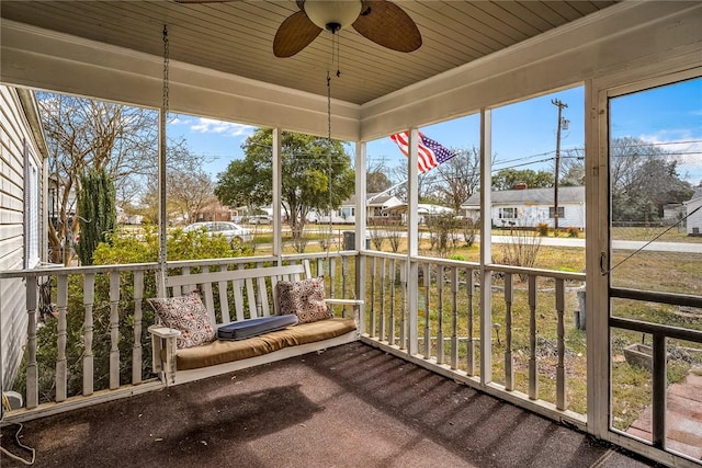 sunroom / solarium with a ceiling fan and a residential view