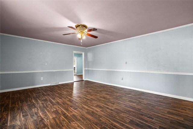 empty room with visible vents, a ceiling fan, wood finished floors, crown molding, and baseboards