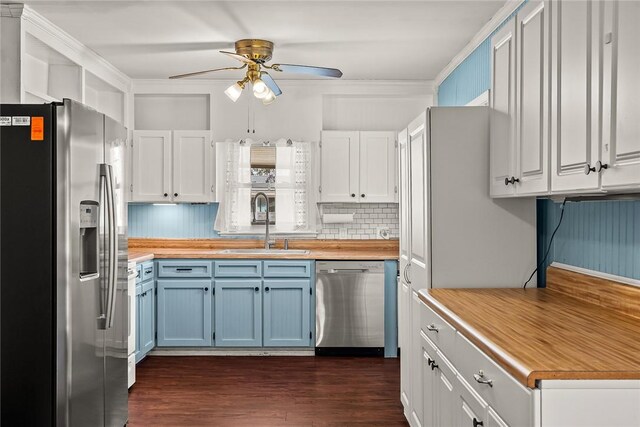 kitchen featuring blue cabinetry, ceiling fan, appliances with stainless steel finishes, dark wood-style floors, and a sink