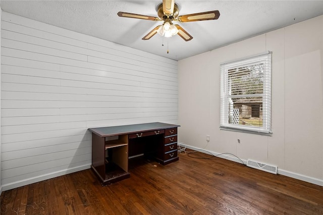 office area with visible vents, a textured ceiling, dark wood-style floors, baseboards, and ceiling fan