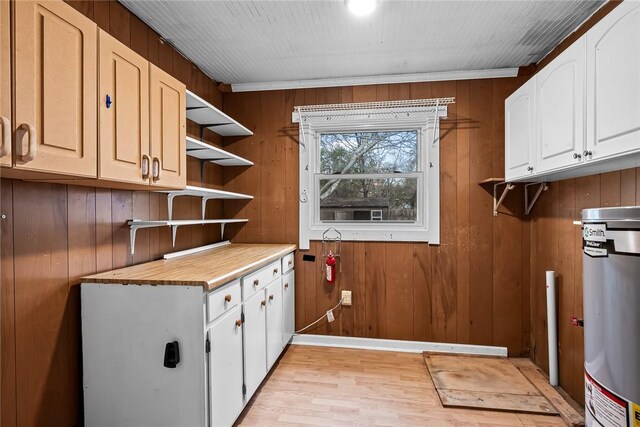 laundry area featuring wooden walls and light wood-type flooring