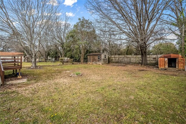 view of yard with an outbuilding, a storage unit, and a fenced backyard
